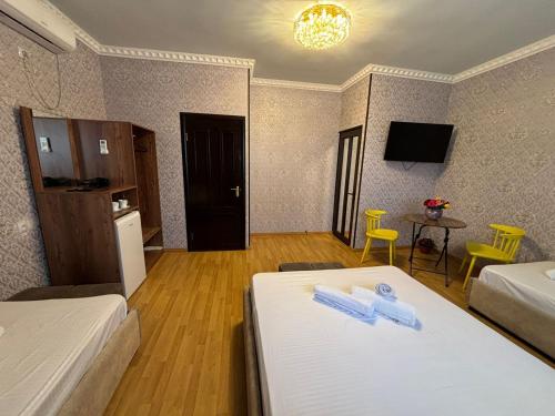 a hotel room with two beds and a table and chairs at Styopa Hotel in Yerevan