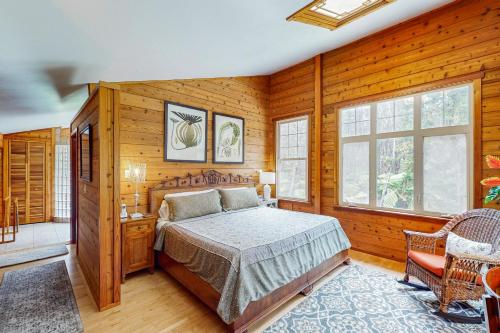 a bedroom with a bed in a room with wooden walls at Hale Hapu'u in Volcano