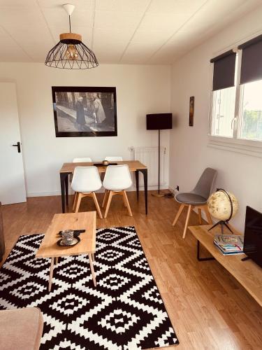 a living room with a table and chairs at Cocon berrichon Châteauroux-Déols in Déols