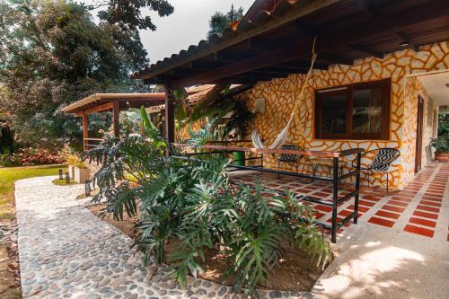 a house with a bench in front of it at Portales del Tayrona Garden Hotel in Calabazo