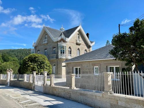 una vecchia casa con una recinzione davanti di Villa Boutique 1880, Escapada Romántica con Spa Privado Exterior, Privacidad y Servicio Personalizado a San Salvador