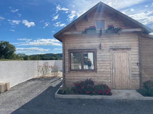 Cette petite maison en bois dispose d'une fenêtre et de fleurs. dans l'établissement Flodelpablo, à Moulézan