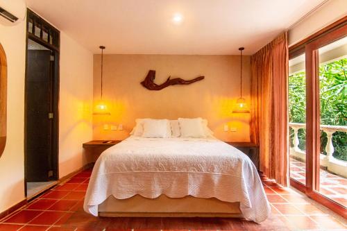 a bedroom with a bed with a antler on the wall at Portales del Tayrona Garden Hotel in Calabazo