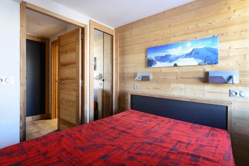 une chambre avec un grand lit avec une couverture rouge dans l'établissement Résidence Backgammon - LE BACKGAMMON MAE-3418, à Les Coches