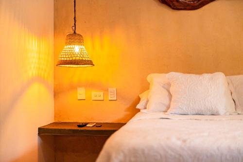 a bedroom with a bed and a light fixture at Portales del Tayrona Garden Hotel in Calabazo