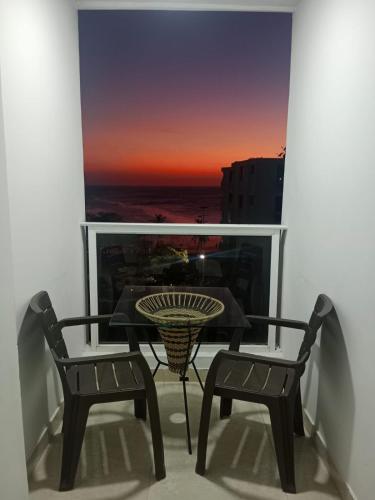 a table and two chairs on a balcony with a view at apartaestudios luna azul rodadero in Gaira