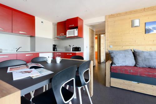 une cuisine avec des armoires rouges et une table et des chaises dans l'établissement Résidence Backgammon - Bel appartement rénové · Proche des pistes · Balcon MAE-3444, à Les Coches