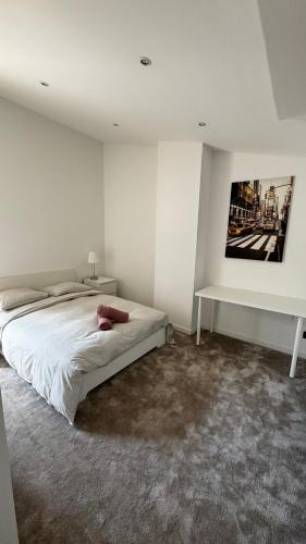 a white bedroom with a bed and a desk at Maison Cosy - Maison de Maitre in Saint-André