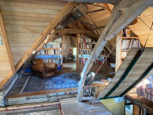 Cette chambre mansardée dispose d'un canapé et d'une bibliothèque. dans l'établissement La fermette, à Herzeele