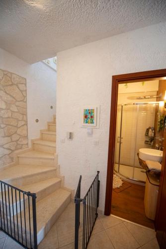 a staircase leading to a bathroom with a sink at Thea Holiday Home in Nea Potidaea