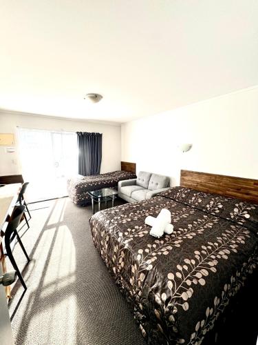 a hotel room with a bed and a couch at Papakura Pioneer Motor Lodge & Motel in Papakura
