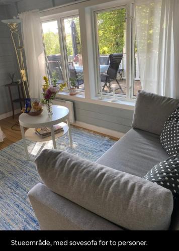 a living room with a couch and a table at Hilltop fjord cottage in Krokstrand