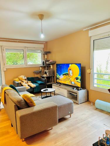 un salon avec un canapé et une télévision à écran plat dans l'établissement Niti, à Cergy