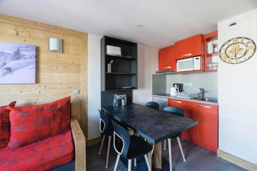 une petite cuisine avec une table et des chaises dans une pièce dans l'établissement Résidence Backgammon - LE BACKGAMMON MAE-3495, à Les Coches