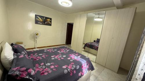 arsa taranga في داكار: غرفة نوم مع سرير وبطانية ورد