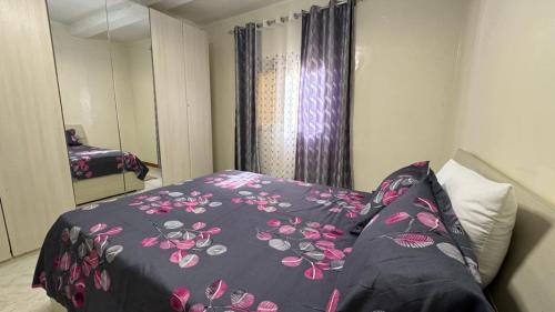 arsa taranga في داكار: غرفة نوم مع سرير وبطانية مزهرة