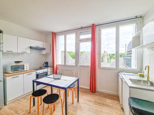 - une petite cuisine avec une table et deux tabourets dans l'établissement Appartement Tropical, à Château-Renault
