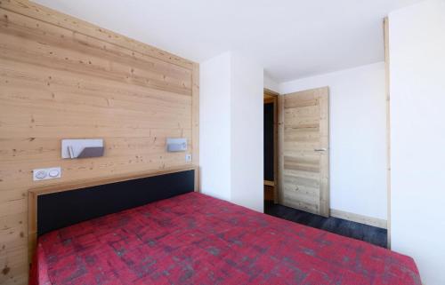 - une chambre avec un lit rouge et un mur en bois dans l'établissement Résidence Backgammon - Appartement confortable · Accès facile aux pistes · Terrasse MAE-3513, à Les Coches