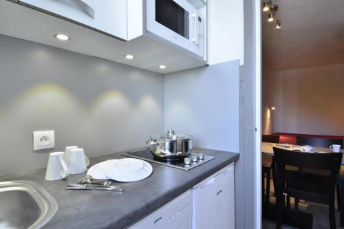 une cuisine avec un évier et un plan de travail dans l'établissement Residence 3000 - Studio pour 4 Personnes 34, à Mâcot La Plagne
