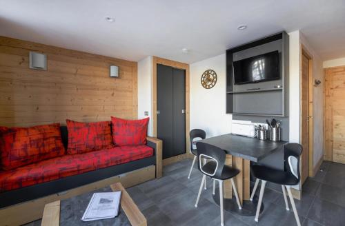 un salon avec un canapé rouge et une table dans l'établissement Résidence Backgammon - LE BACKGAMMON MAE-3551, à Les Coches