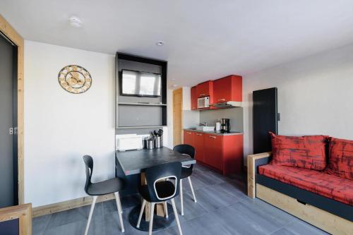 un salon avec un canapé rouge et une table dans l'établissement Résidence Backgammon - LE BACKGAMMON MAE-3553, à Les Coches