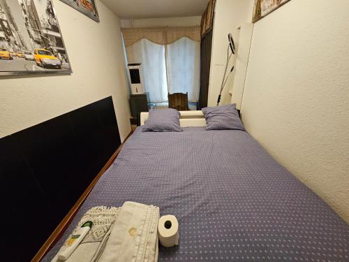 a bedroom with a bed with purple sheets and a roll of toilet paper at Great Apartment near Bern & Up to 7 Seats Cars Rental Option in Ittigen