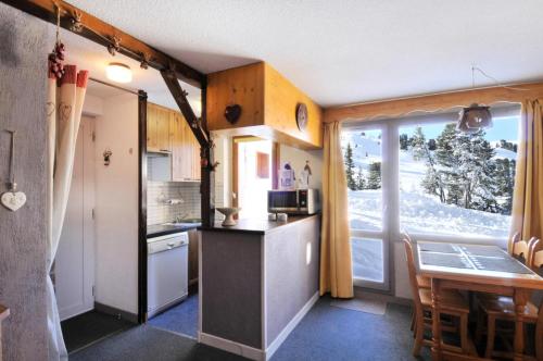 une petite cuisine avec une table et une fenêtre dans l'établissement Résidence Turquoise - 2 Pièces pour 5 Personnes 95, à Mâcot La Plagne