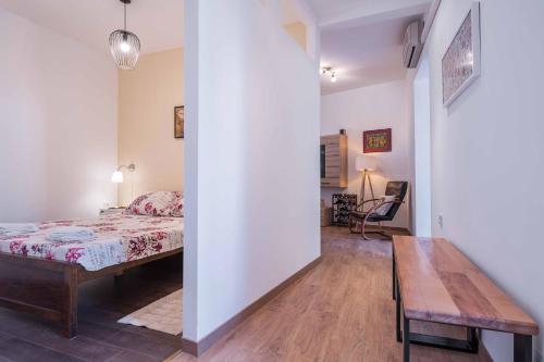 a bedroom with a bed and a wooden table at Porta Aurea sunny studio in Pula