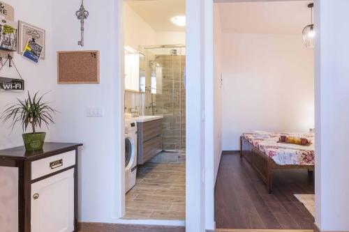 a bathroom with a sink and a washer and dryer at Porta Aurea sunny studio in Pula