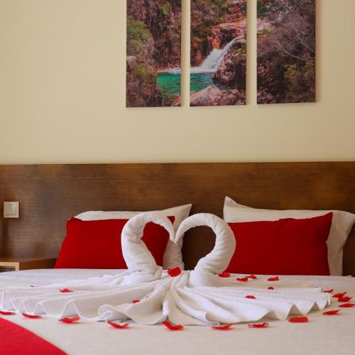 two swans made out of roses are on a bed at Outeiro do Moinho in Campo do Gerês