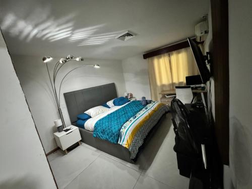 a bedroom with a bed with a blue blanket at Villa Ho Omaika I Los Delfines Tambor in Pochote