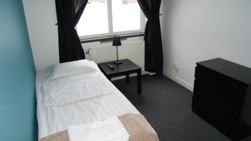 a bedroom with a bed and a table and a window at Vandrarhem 11 RUM & KÖK in Sandviken