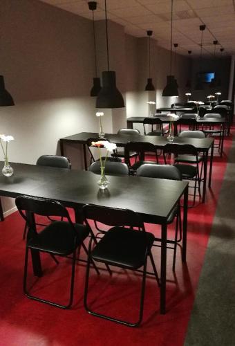 a group of tables and chairs in a room at Vandrarhem 11 RUM & KÖK in Sandviken