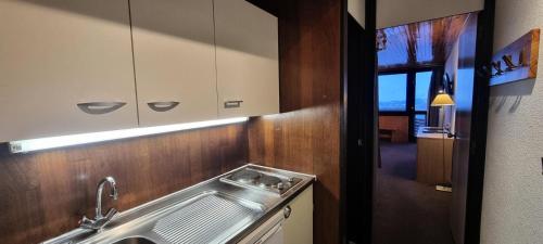 - une cuisine avec un évier en acier inoxydable et un miroir dans l'établissement Résidence Zodiac - Studio pour 4 Personnes 394, à Aime La Plagne