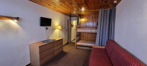 une chambre avec un lit, un canapé et une télévision dans l'établissement Résidence Zodiac - Studio pour 4 Personnes 394, à Aime La Plagne