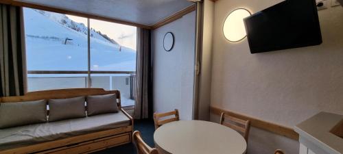 Cette petite chambre dispose d'une table et d'une fenêtre. dans l'établissement Résidence Etoile - Studio pour 4 Personnes 414, à La Plagne Tarentaise