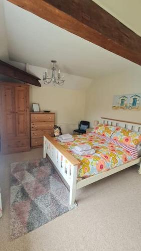 a bedroom with a large bed and a dresser at Wish End Cottage in Ratton Village