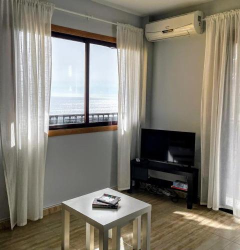 a living room with a table and a large window at La Pura Vida in Tazacorte