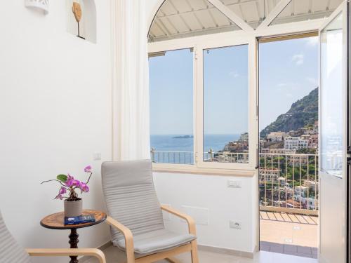 a white room with a chair and a table at Casa Vittorina - De Vivo Realty Positano in Positano