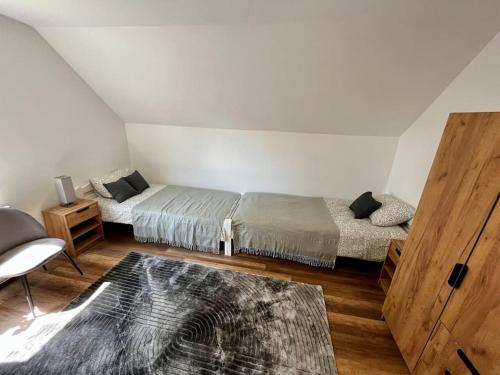 a bedroom with two beds and a wooden floor at Charming flat in Maribor