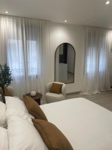 une chambre avec un lit, un miroir et une chaise dans l'établissement Appartement, à La Plaine-Saint-Denis