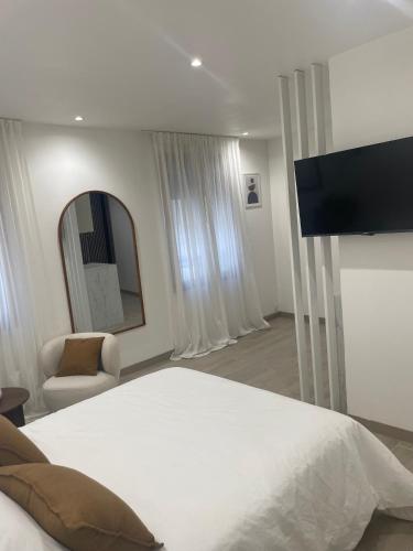 une chambre avec un grand lit blanc et un miroir dans l'établissement Appartement, à La Plaine-Saint-Denis