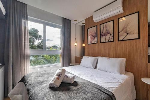 ein Hotelzimmer mit einem Bett und einem Fenster in der Unterkunft Rosa Edifício Bav in Gramado