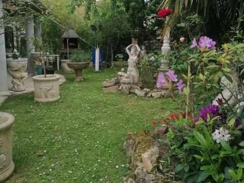 un jardin avec des fleurs et des statues dans l'herbe dans l'établissement Fastrentbnb Villepinte chambre cozy, à Villepinte