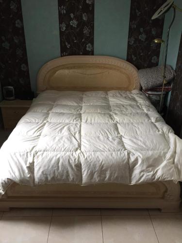 - un lit dans une chambre avec une couette blanche dans l'établissement Fastrentbnb Villepinte chambre cozy, à Villepinte