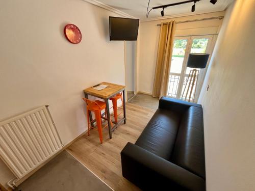 ein Wohnzimmer mit einer Couch, einem Tisch und einer Uhr in der Unterkunft Lotila Flats Rio Caudal in Figaredo