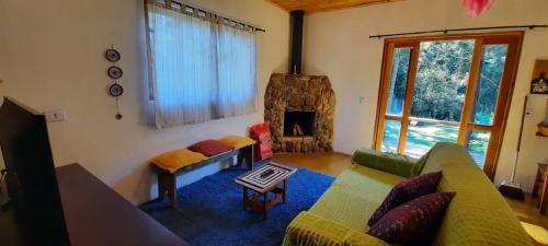 a living room with a couch and a fireplace at Casa Araucária no Refugio Pinheiro Beira Rio in Sapucaí-Mirim