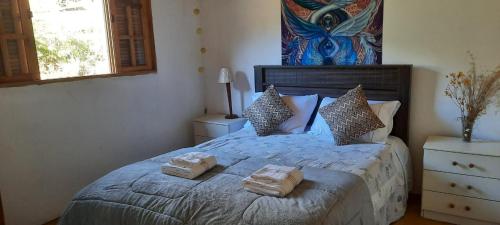 a bedroom with a bed with two towels on it at Casa Araucária no Refugio Pinheiro Beira Rio in Sapucaí-Mirim