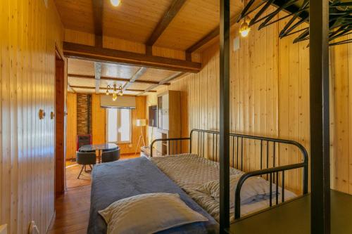 a bedroom with a bed in a room with wooden walls at Sierra Nevada apartamento de madera muy cálido con buenas vistas y WiFi in Sierra Nevada