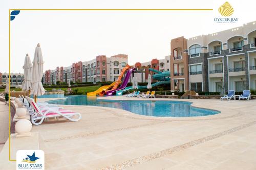 una piscina in un resort con scivolo d'acqua di Oyster bay Suite 01 a Abu Dabab